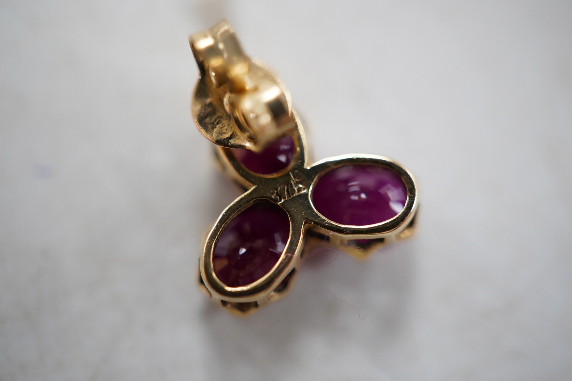 A modern pair of 9ct gold and three stone ruby cluster set ear studs, 9mm, gross weight 1.6 grams. Condition - good